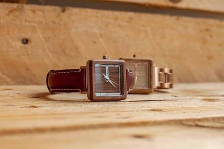 montres femme en bois, une avec son bracelet cuir et l'autre avec son bracelet bois et métal, sur un fond de palettes en bois